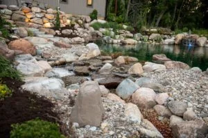 Backyard rock garden with waterfall and pond.